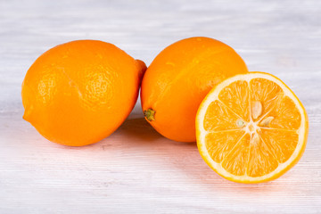 Orange lemons with bones on white wooden background