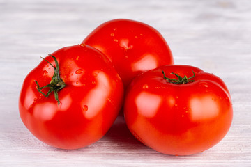 Round juicy tomatoes with water droplets