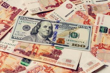 American hundred dollars on the background of Russian 5000 rubles.