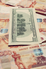 one hundred dollar bill lies on 5000 Russian rubles, the side where the hall of independence is depicted.
