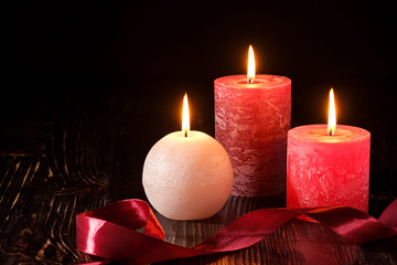 Three wax flame candlelight with ribbon in dark romantic light, love dating, Valentine's day, selective focus
