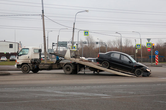 loading a car after an accident on a tow truck in the middle of the road