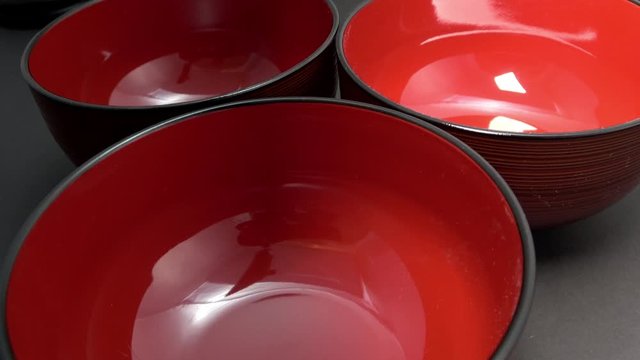 Red empty Japanese lacquer bowls are turning
