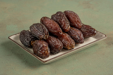 closeup of delicious date fruits on a green background