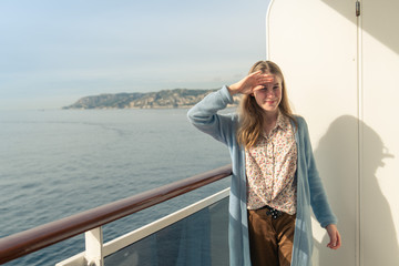 Cruise ship vacation. Teenager girl relaxing on luxury cruise ship balcony. Portrait of a happy beautiful girl on a cruise ship at sunrise