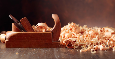 Old wooden jointer and shaving on wooden table.