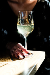 Woman's hand holding a glass of white wine