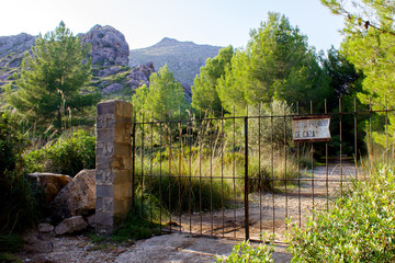 Closed Gate with Sign „Private Hunting Area“ in Spanish in the City of Cala Sant Vicent, Mallorca, Spain 2018 - 314336586
