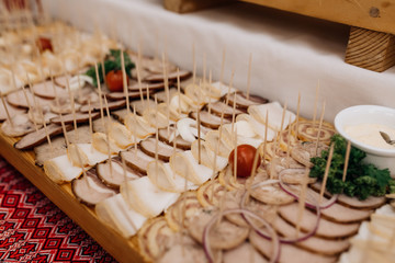 Delicious meat snacks on the wooden tray with pork, onion and parsley