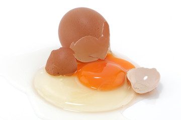 Raw egg cracked on a white surface