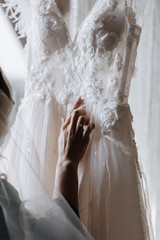 Bride is looking on the beautiful stylish white wedding dress