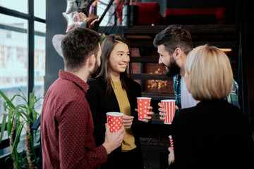 In a modern office center group of multiethnic workers while have a coffee break have a friendly conversation smiling and enjoying the coffee