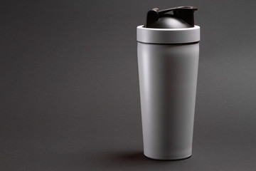 one white thermal bottle shaker for sports nutrition on a gray background.