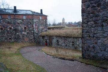 Ancient historical stone fortifications overgrown with grass and road on the Fort Suomenlinna island in Helsinki in Finland on an autumn day