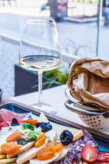 Antipasti on wooden plate, salad with anchovy, bread on paper