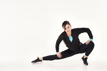 Young athletic woman making yoga and gymnastics stretching exercises isolated on white 