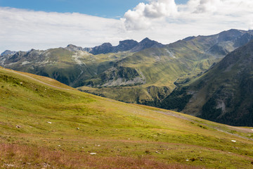 View on Pennine Alps and green alpine meadows from the top of Sorebois on a cloudy summer day. Zinal, Anniviers, Valais, Switzerland