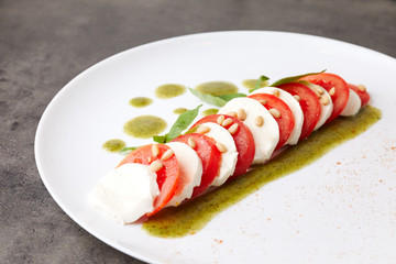 sliced cheese and tomato, laid out in a row and poured with sauce