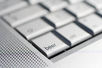 Close up shot of a laptop keyboard with a beer key in focus.