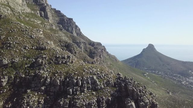 4K high quality aerial sunny blue sky footage of spectacular scenic Lion's Head Mountain, rocky hills with hiking trails, Atlantic Ocean coast panorama in Western Cape, Cape Town, South Africa
