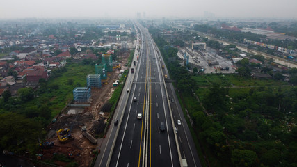 BEKASI, WESTJAVA, INDONESIA : JANUARY 10 202 : Aerial drone view of highway multilevel junction road with moving cars after rainy. Cars are blurred