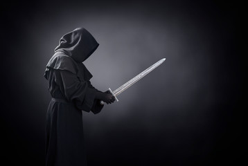 Ghostly figure with medieval sword in the dark