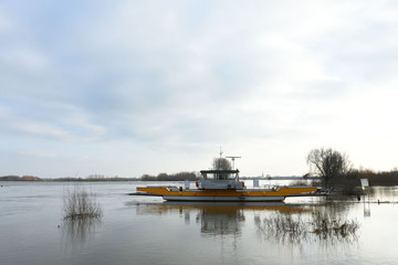 Obraz premium ferry waiting on flooded meadow near river IJssel