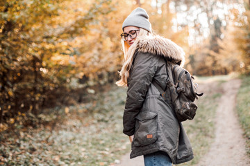 Hiking and travel along in the forest. Concept of trekking, adventure and seasonal vacation. Young woman walking in woods.