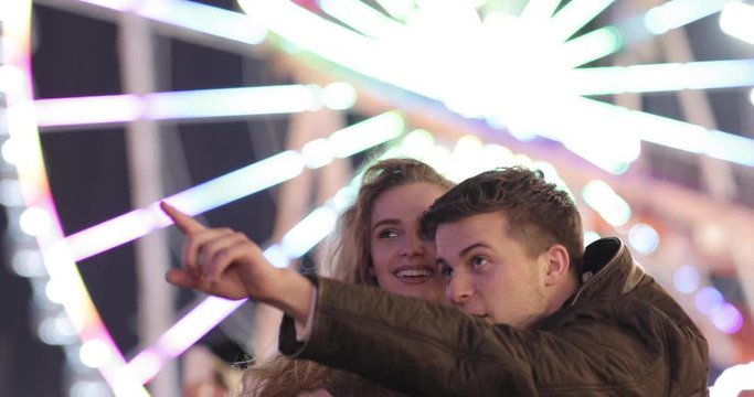 Happy couple in love having fun at amusement park
