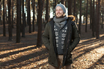 close up portrait of a bearded hipster tourist in gray hood man in the sunlight