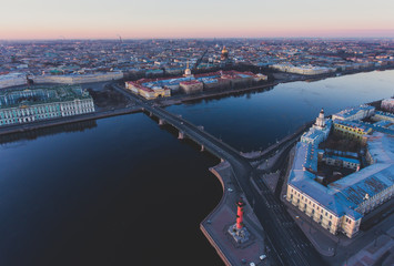 Fototapeta premium Beautiful aerial morning view of Saint-Petersburg, Russia, The Vasilievskiy Island at sunrise, Isaacs Cathedral, Admiralty, Palace Bridge, cityscape and scenery beyond the city, shot from drone