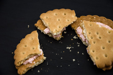 sandwich crackers on a black background. Pieces and crumbs of cookies. Close-up.