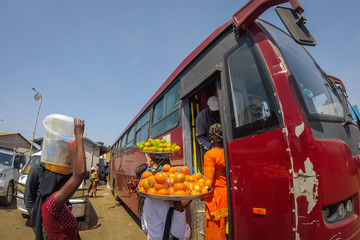 Fisheye picture of african women from gambia selling fruit and other goods on the ferry terminal in...