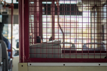 A place for a conductor in a metropolitan bus in Dakar, Senegal. Cashier surrounded by metal fence to prevent people attacking the conductor in an african urban transport.