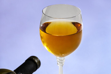 a glass of wine and a part of the bottle. Close-up.