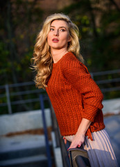 Trendy beauty. autumn woman curly hair outdoor. girl long blond hair city walk. girl in corrugated skirt and sweater. Pleated trend. haidresser and makeup. fall fashion season. female beauty