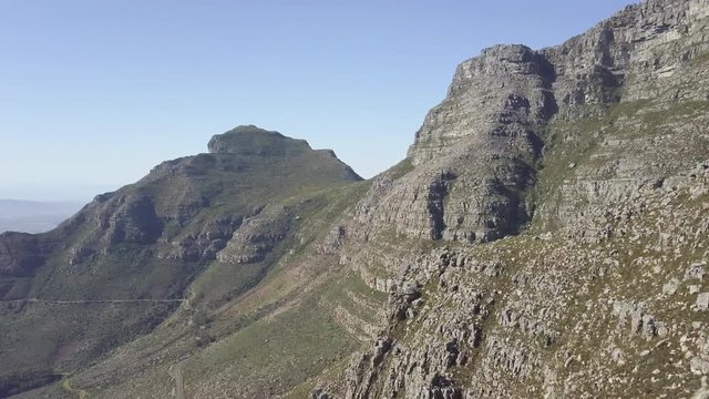 Aerial majestic scenic drone flight view of Table Mountain in late afternoon sun against blue sky. Steep sand stone cliff and tectonic lines. Majestic and magical mountain landscape with no people