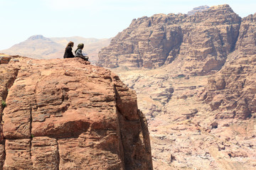 Typical Bedouins sitting on rock at High place of sacrifice in ancient city of Petra in Jordan