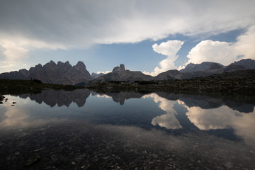 Dolomites mountains in Italy reflection in lake clouds