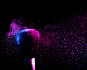 flying shadows from colliding makeup brushes. pink and blue light. black background. 