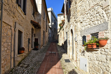 A narrow street between the old houses of a medieval town in Italy
