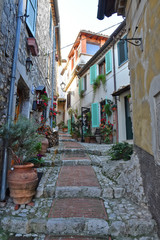 Fototapeta na wymiar A narrow street between the old houses of a medieval town in Italy
