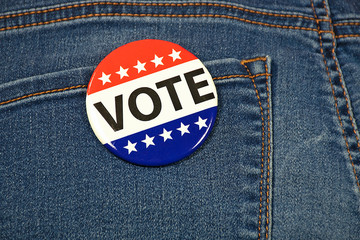 close up of patriotic election campaign pin on rear pocket of blue jeans
