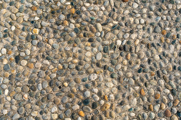 Texture and background with small pebbles, sidewalk on a street