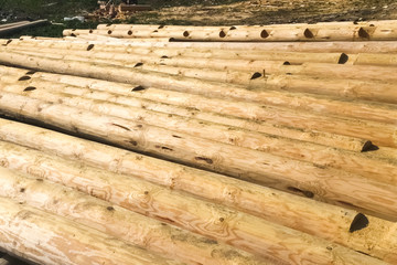 Drying and assembly of wooden log house at a construction base.
