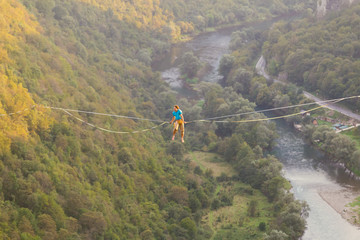 A man sits on a stretched sling.