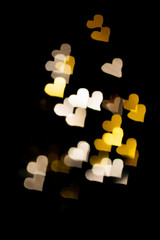 Abstract light, golden bokeh pattern in heart shape. St Valentines Day or Holiday concept, background image.