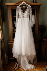 Fototapeta na wymiar Beautiful tender wedding dress is hanging in the room