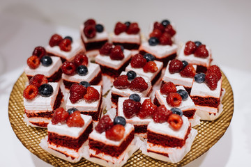 Portions of biscuit desserts stand on the catering table