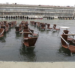 chairs and tables in the water during the flood in Venice in Ita